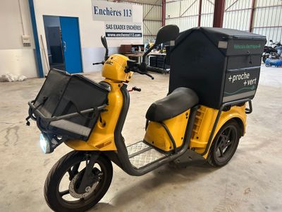 un scooter jaune avec un coffre noir à l'arrière