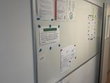 an image of a hallway with a bulletin board and a refrigerator