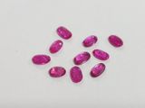 a group of pink sapphires on a white surface