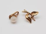 gros plan d'une paire de boucles d'oreilles sur une surface blanche