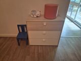un parquet en bois massif dans une chambre équipée d'une commode, d'une chaise et d'une lampe