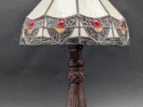 a table lamp with a stained glass shade on top of it