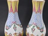 pair of vases sitting on a black surface with a black background