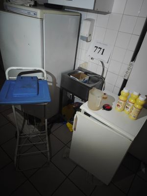 une petite cuisine équipée d'un réfrigérateur et d'une table