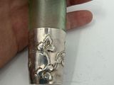 a person holding a green and silver lighter in their hand