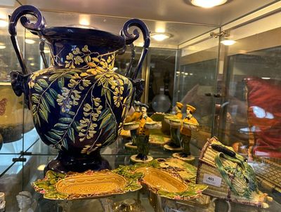 une vitrine en verre sur laquelle est posé un vase bleu