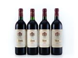 three bottles of wine are lined up on a white surface