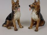 deux figurines de chiens assis l'une à côté de l'autre
