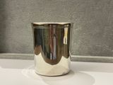 a silver cup that is sitting on a white table