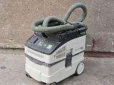 un aspirateur posé par terre, muni d'un tuyau