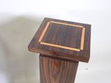 a small wooden table with a square top on it