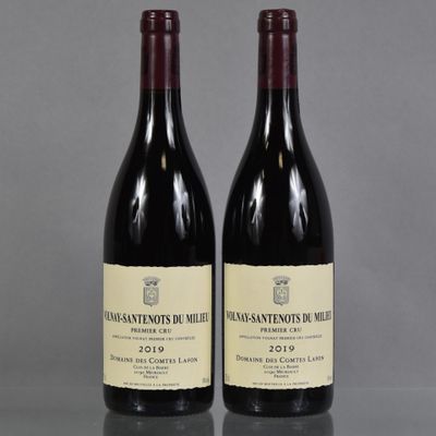 two bottles of red wine sitting on top of a table
