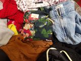 a pile of clothes that is sitting on a bed