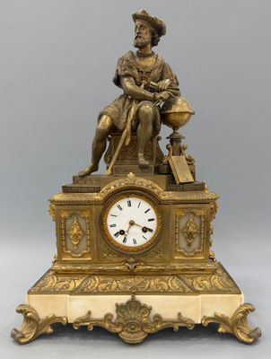 une horloge en or sur laquelle est assis un homme