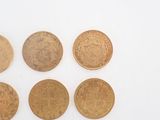 six different british coins sitting on top of each other on a white surface