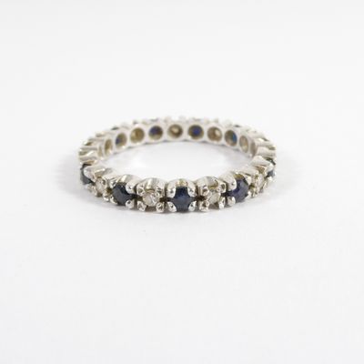 un gros plan d'une bague en or blanc sertie de saphirs bleus