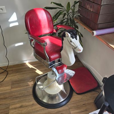 a red chair with a horse head on it in the corner of a room