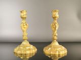 pair of antique brass candlesticks on a black table