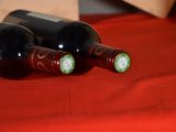 three bottles of wine sitting on a red cloth