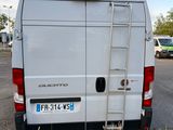 a white van parked in a parking lot with a ladder on the back of the van