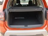 the back end of an orange car with its trunk open