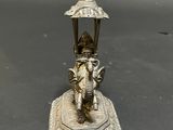 a statue of an elephant holding an umbrella on top of a table