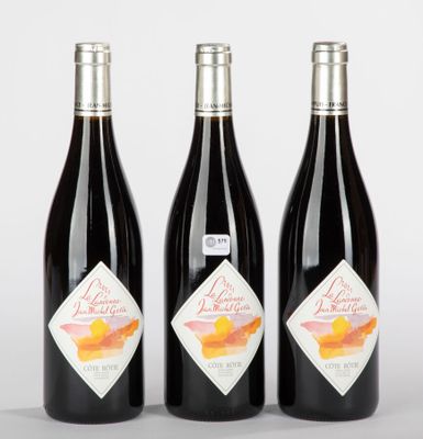 trois bouteilles de vin sont alignées sur une surface blanche