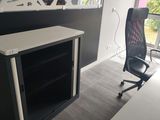 un bureau noir et blanc avec une chaise noire et un tableau accroché au mur