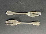 two spoons and a fork on a table