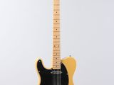 an electric guitar hanging from a string on a wall