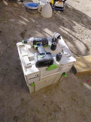 une boîte blanche posée sur le sol, avec des outils dessus