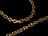 a close up of a gold chain on a black background