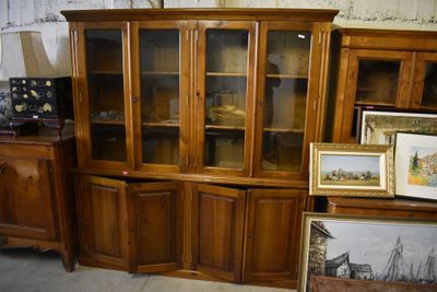 a wooden cabinet with glass doors and pictures on it