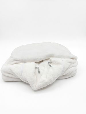 une couverture blanche pliée sur une surface blanche
