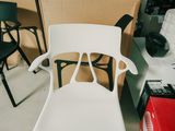 une chaise blanche dans une pièce où se trouvent de nombreuses chaises