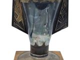 un vase en verre posé sur un socle en bois