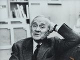 black and white photograph of a man in a suit sitting at a desk