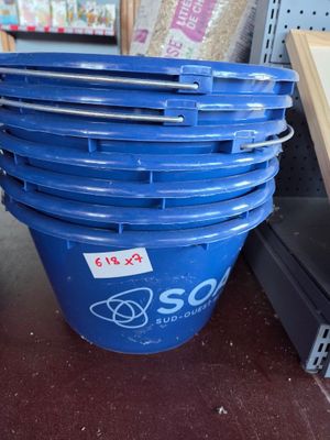 a large blue bucket sitting on the floor next to a shelf