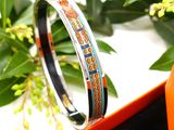 an image of a bracelet with orange and blue designs on it