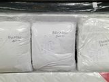 three white pillows in a plastic bag on a shelf