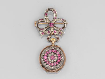 un gros plan sur une broche rose et blanche ornée d'un nœud