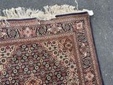 an oriental rug with fringes laying on the ground