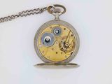 a silver and gold pocket watch with a chain around it