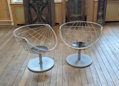 pair of chairs in a room with wood flooring and a clock