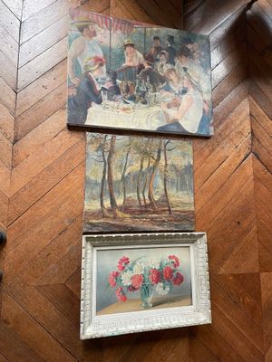 three paintings on the floor next to a vase of flowers