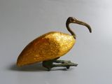 a golden bird that is standing on a skateboard