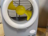 a small fan sitting on top of a table next to a box