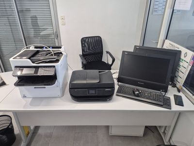un bureau sur lequel se trouvent un ordinateur portable et une imprimante