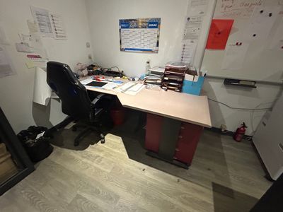 a desk with a chair and a mirror in the corner