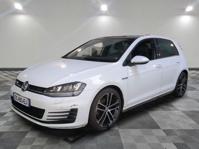 Une Volkswagen Golf R-Line blanche est garée sur un sol à damier